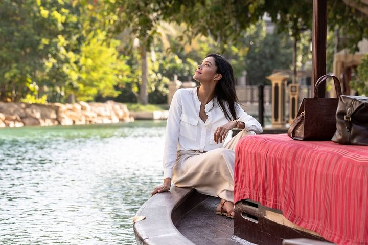 Experience the charm of Souk Madinat Jumeirah as you enjoy a serene Abra boat ride surrounded by lush landscapes and stunning architecture perfect for unforgettable memories.